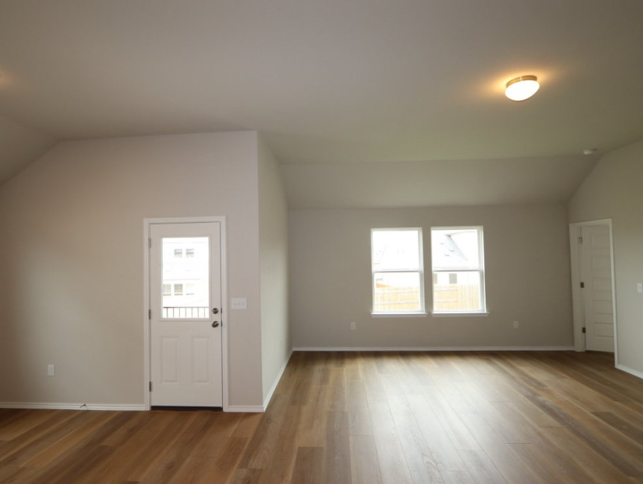 11905 Dillon Fls Drive Austin, TX 78747 - Photo 3 of 9 an empty room with wooden floor and windows