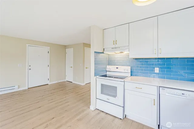 an empty room with wooden floor and window