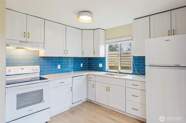 a kitchen with white cabinets and a refrigerator