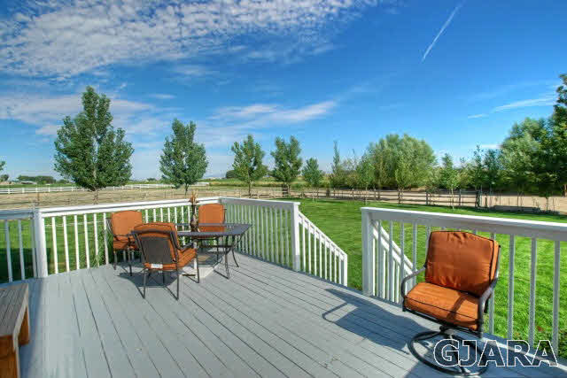 1598 P Road Loma, CO 81524 - Photo 18 of 25 a balcony with wooden floor outdoor seating and trees in the background