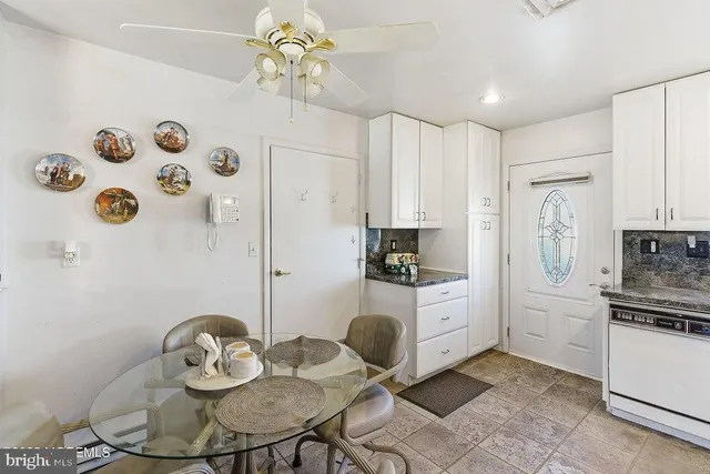 a kitchen with stainless steel appliances a dining table chairs and white cabinets