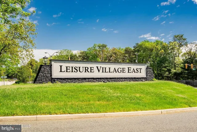 a view of a sign board with garden in the background