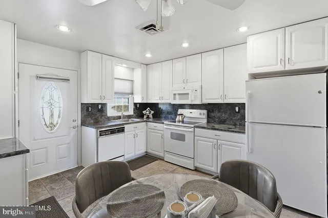 a kitchen with stainless steel appliances granite countertop a refrigerator a stove microwave and cabinets