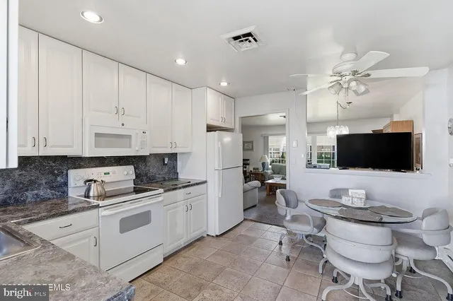 a kitchen with a sink white cabinets and stainless steel appliances