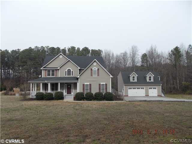 a front view of a house with a yard and large tree
