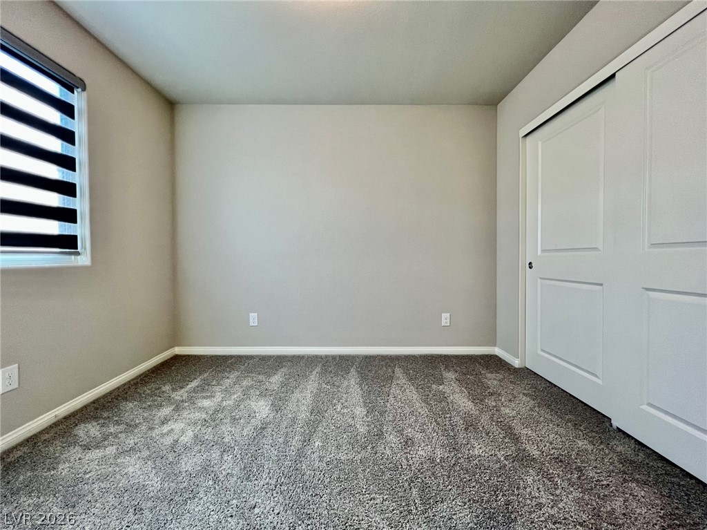 7845 Morganite Avenue Las Vegas, NV 89113 - Photo 20 of 21 Well-lit room featuring plush carpeting and a convenient sliding closet door.