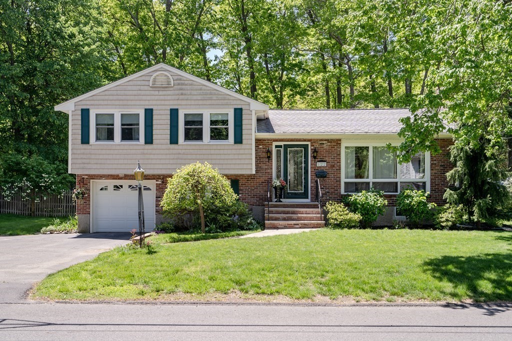 a front view of a house with a yard and potted plants