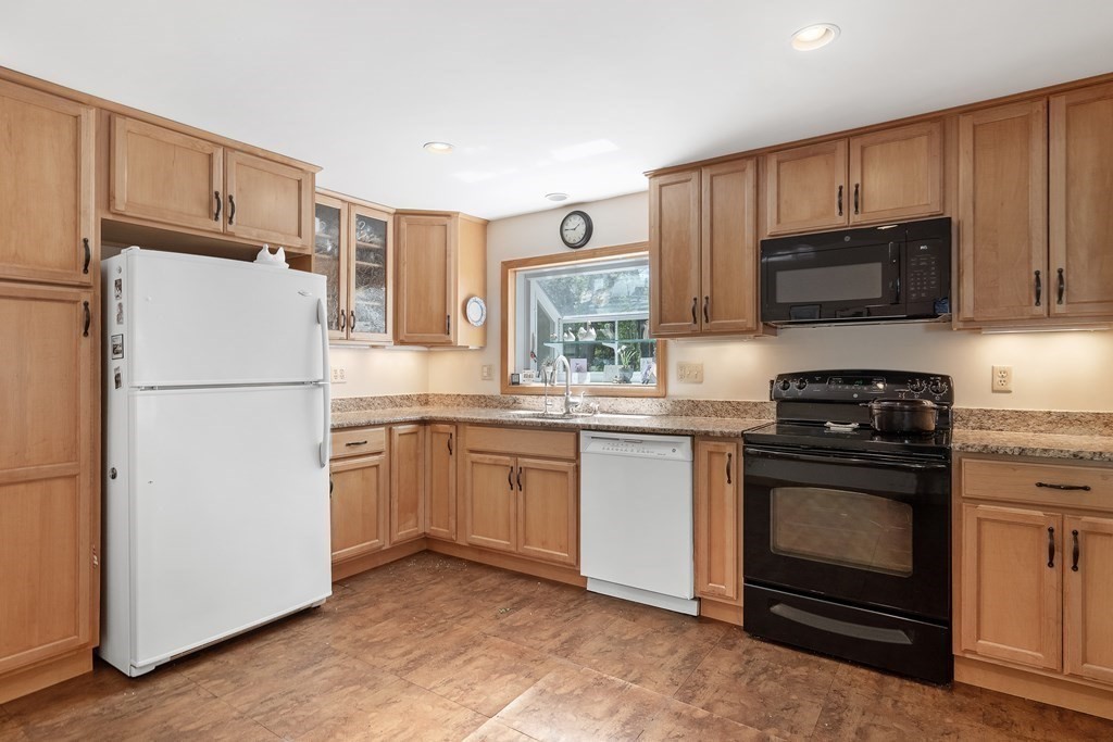 122 Chickering Road Dedham, MA 02026 - Photo 12 of 41 a kitchen with granite countertop a refrigerator stove and microwave