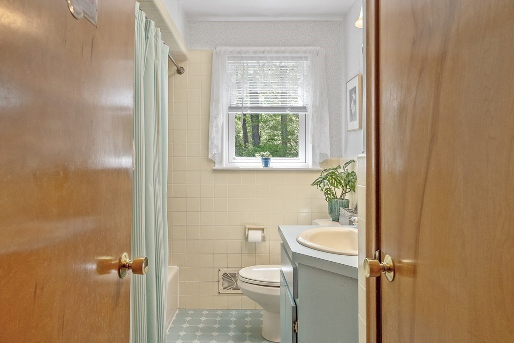 122 Chickering Road Dedham, MA 02026 - Photo 25 of 41 a bathroom with a granite countertop toilet a sink and a shower