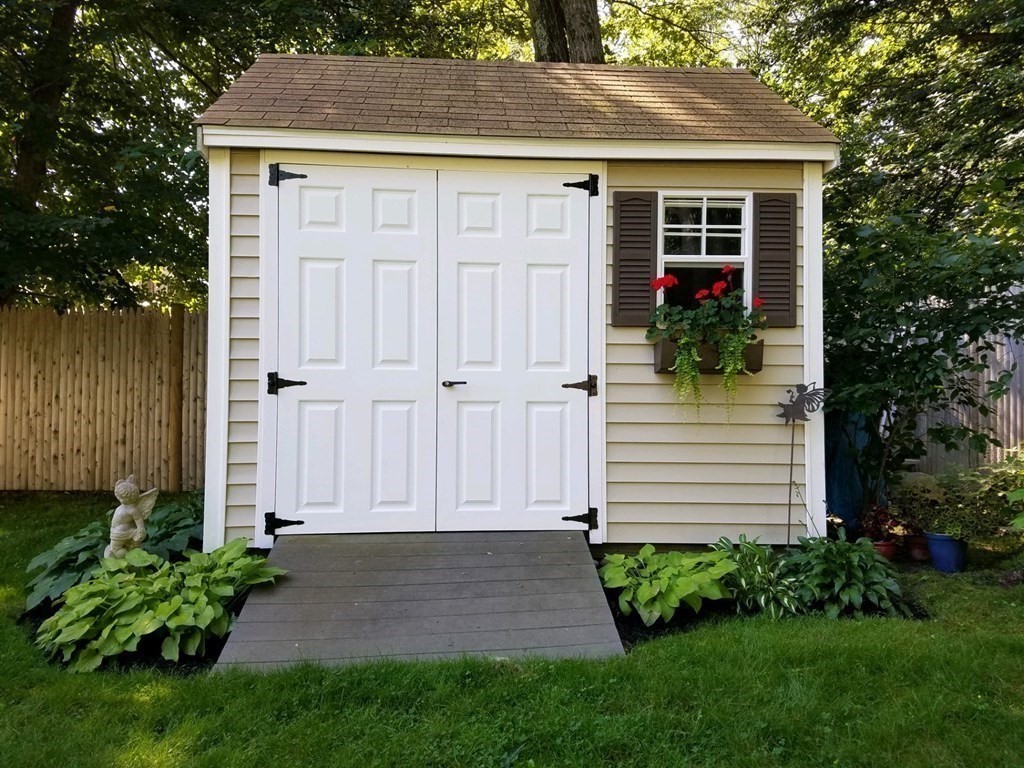 122 Chickering Road Dedham, MA 02026 - Photo 39 of 41 a view of a house with potted plants and a yard with plants