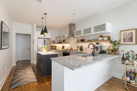 a living room with furniture and kitchen view