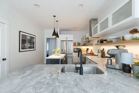 a bathroom with a granite countertop sink a large mirror and a window