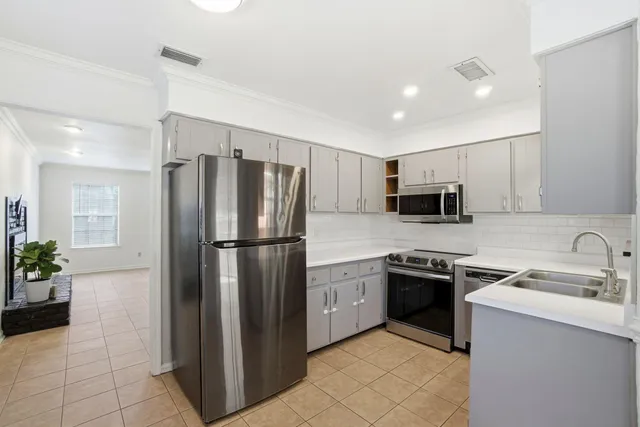 a kitchen with a sink a window and cabinets