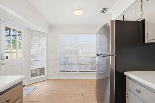 an empty room with chandelier fan and windows