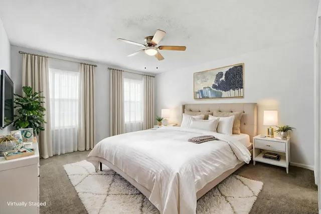 an empty room with chandelier fan and windows