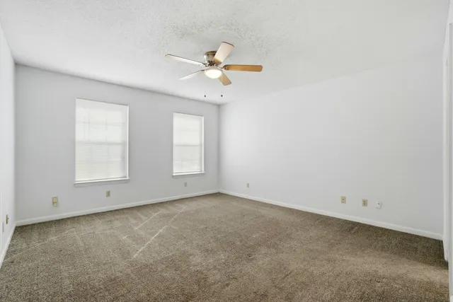 an empty room with closet and a chandelier fan
