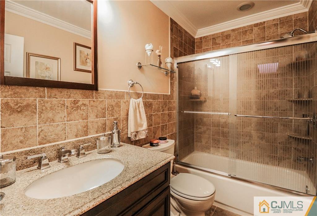 7307 Hana Road Edison, NJ 08817 - Photo 18 of 24 a bathroom with a granite countertop sink toilet and shower