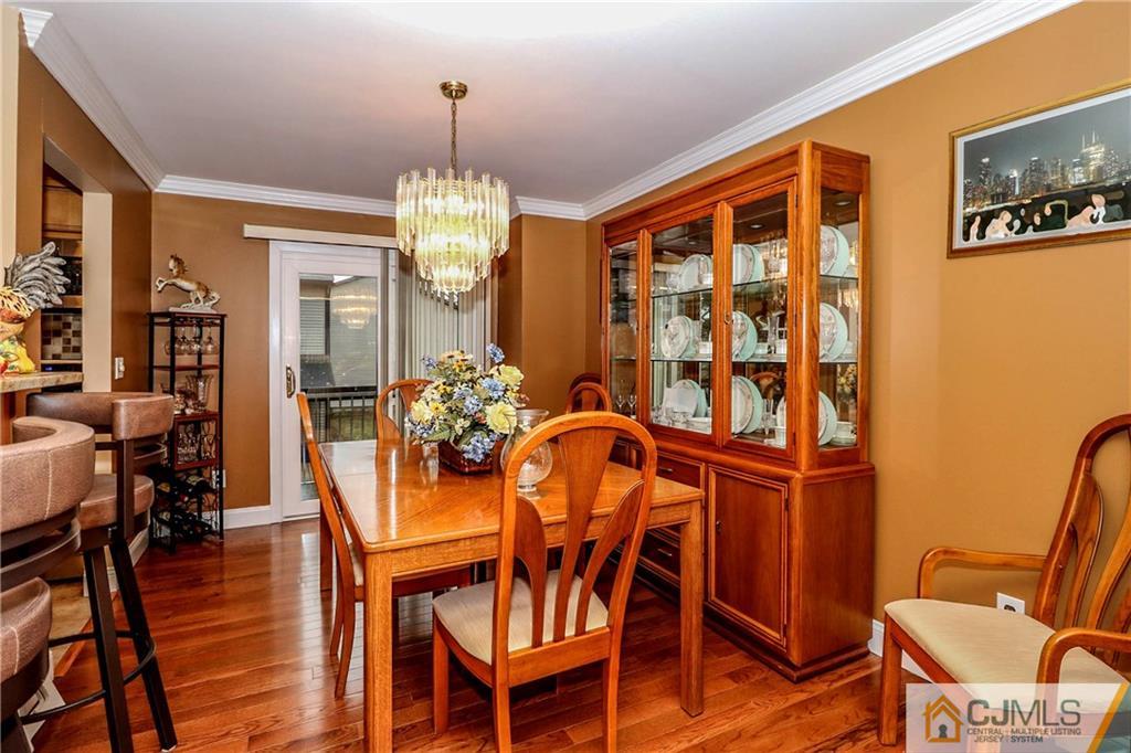 7307 Hana Road Edison, NJ 08817 - Photo 5 of 24 a dining room with furniture a chandelier and wooden floor