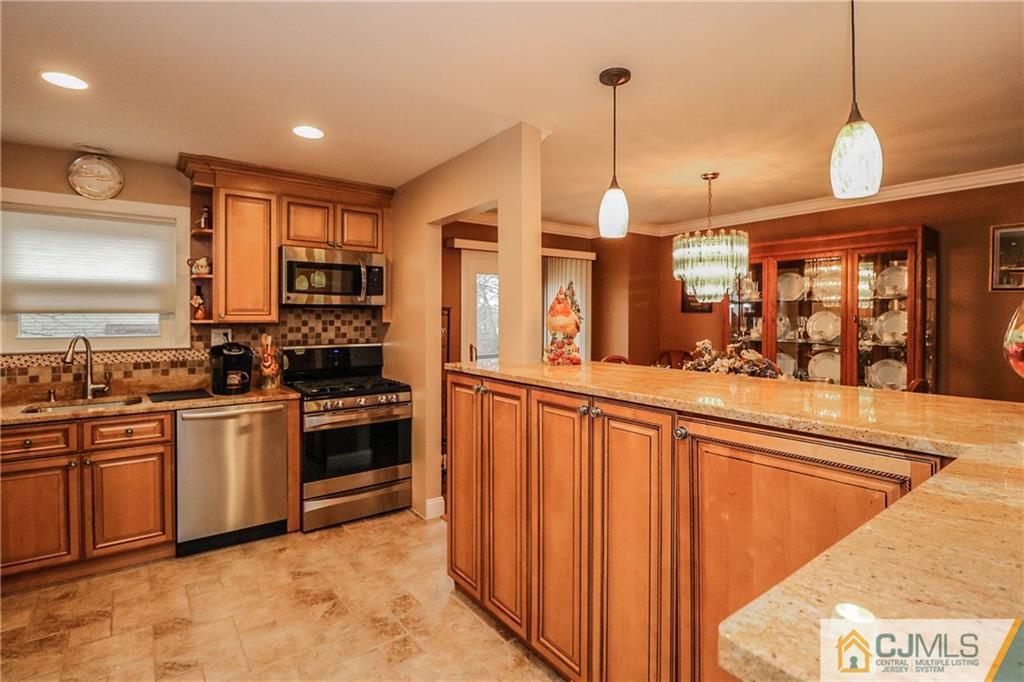 7307 Hana Road Edison, NJ 08817 - Photo 10 of 24 a kitchen with stainless steel appliances granite countertop a stove a sink and a refrigerator