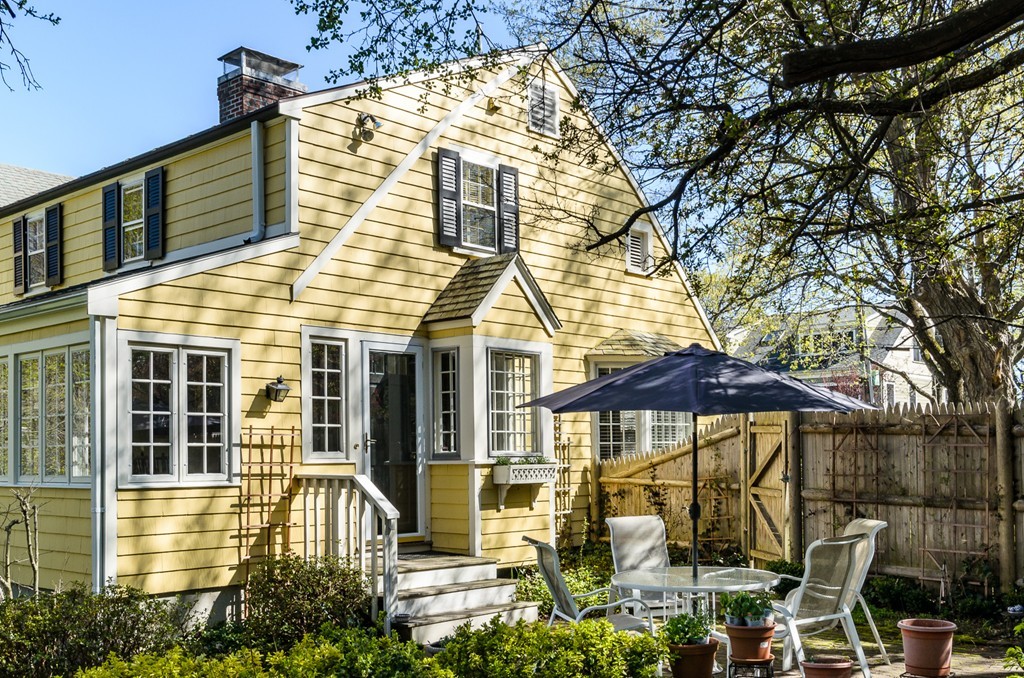 68 Old Farm Road Newton, MA 02459 - Photo 21 of 23 a view of a white house with large windows and table and chairs under an umbrella