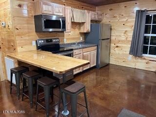 138 Mathews Road Oneida, TN 37841 - Photo 7 of 31 a kitchen with stainless steel appliances a stove a sink a microwave and wooden cabinets