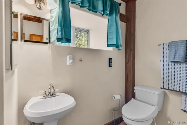 a bathroom with a toilet a sink and mirror