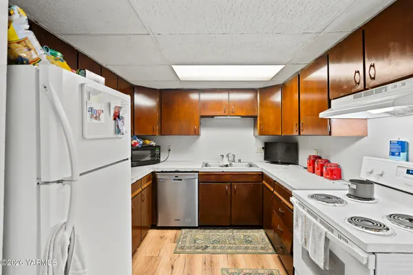 a kitchen with a sink a refrigerator and cabinets