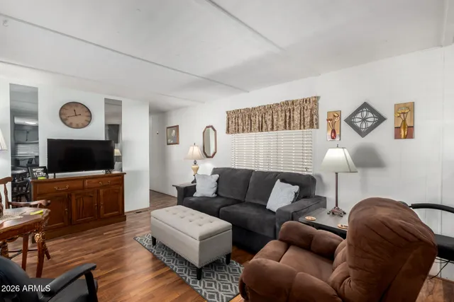 a living room with furniture a flat screen tv and a large window