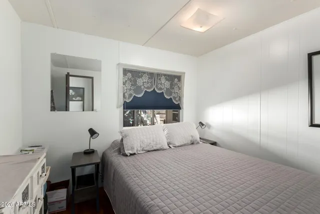 a bedroom with a bed and a painting on the wall