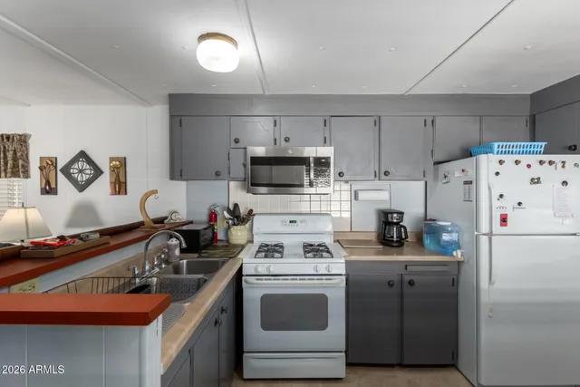 a kitchen with refrigerator a stove a sink and a stove
