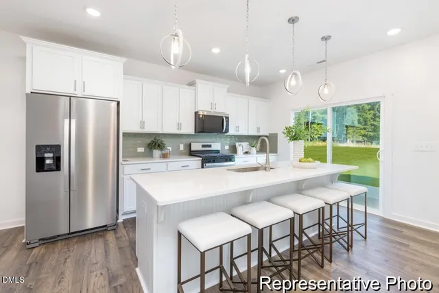 a kitchen with kitchen island a dining table and chairs