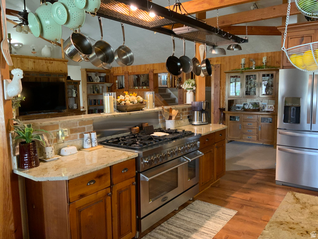 1061 Copper Street Stockton, UT 84071 - Photo 10 of 43 Gourmet kitchen featuring a professional-grade stainless steel range, light-toned granite countertops, rich wood cabinetry, and wood-finish flooring