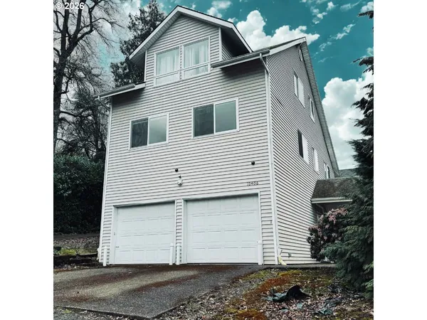 a view of a house with a yard and garage