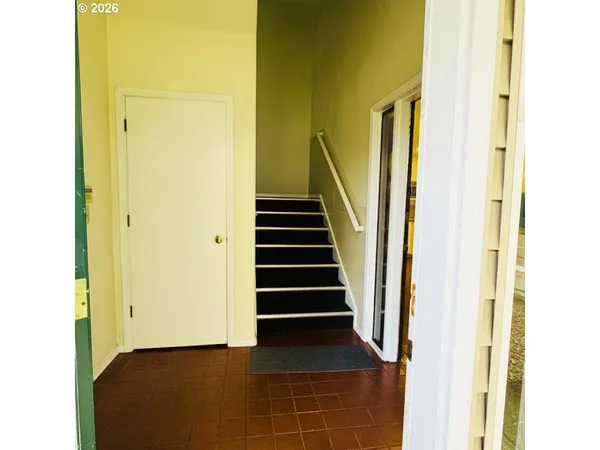 a view of a hallway with stairs and a wooden floor