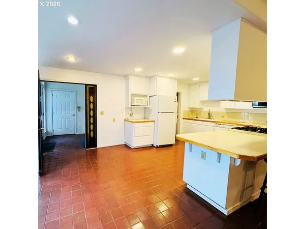 a view of a kitchen with a sink and a refrigerator