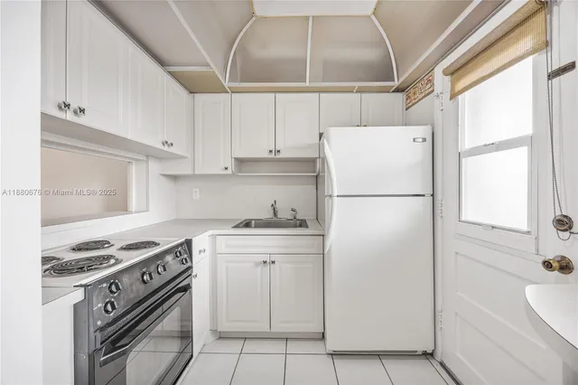 a kitchen with a stove a refrigerator and a window
