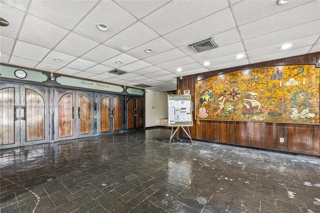 a room with pool table and windows