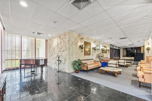 a living room with patio furniture and a large window
