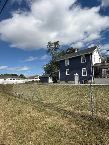 a view of a house with a yard next to a lake