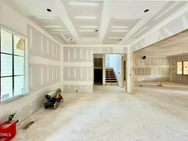 a view of an empty room with a fireplace and a window