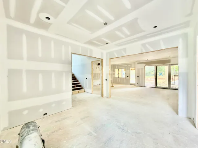 a view of an empty room with a fireplace and a window