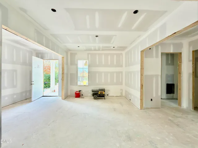 a view of an empty room with a fireplace and a window