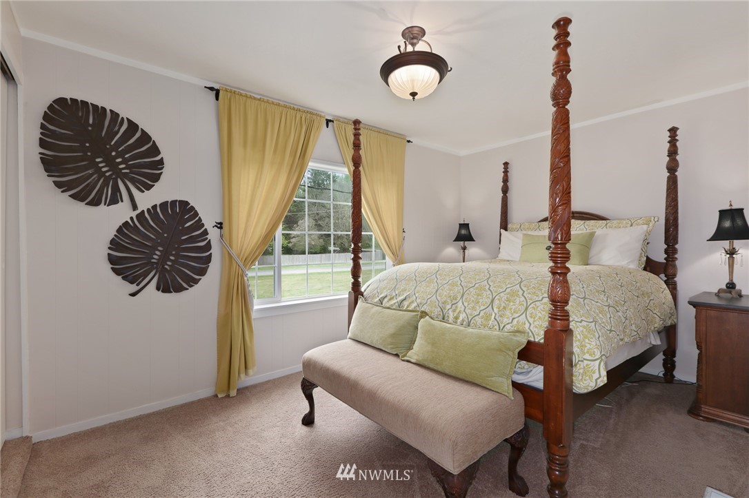 4440 Preston-Fall City Road Southeast Fall City, WA 98024 - Photo 16 of 38 a bedroom with a bed and a chandelier