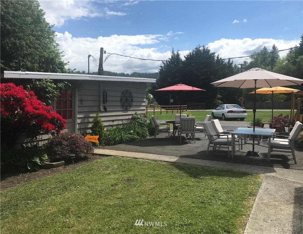 4440 Preston-Fall City Road Southeast Fall City, WA 98024 - Photo 38 of 38 a view of a patio with chairs and a table and chairs under an umbrella
