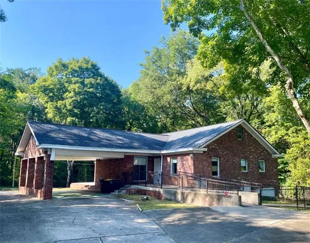 a front view of house with yard and trees in the background