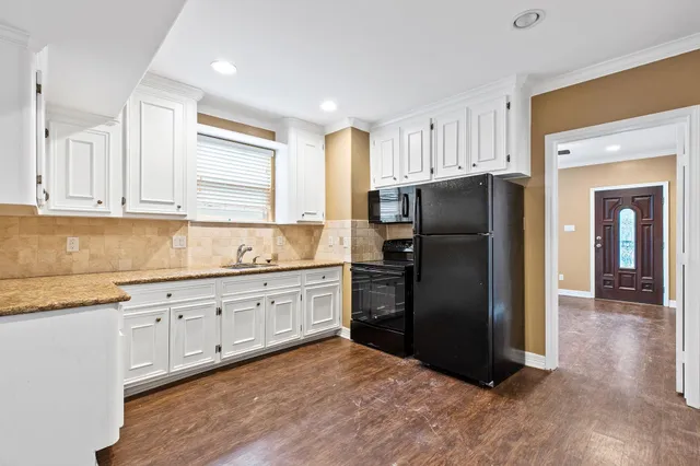 a kitchen with granite countertop a refrigerator and a sink