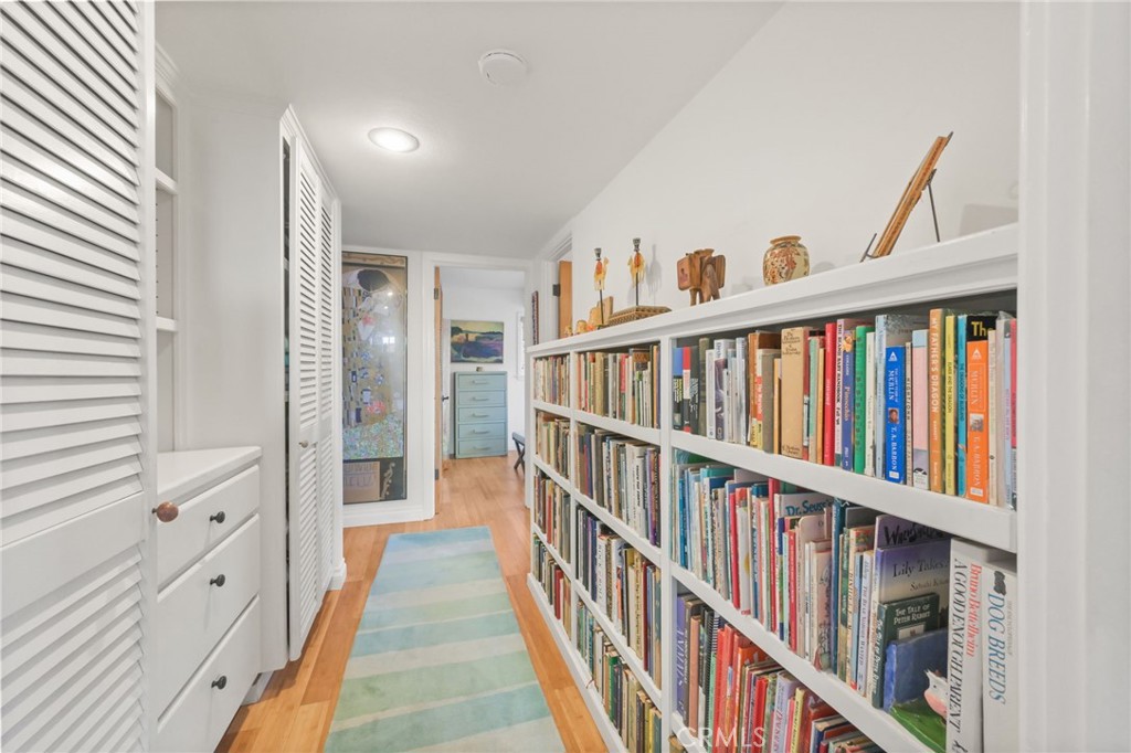 34041 El Contento Dana Point, CA 92629 - Photo 14 of 23 The hallway between the 2 bedrooms with a book case, storage closets and a built in cabinet with shelves and storage.