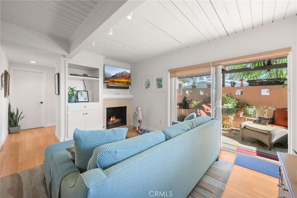 34041 El Contento Dana Point, CA 92629 - Photo 5 of 22 a living room with furniture a fireplace and a floor to ceiling window