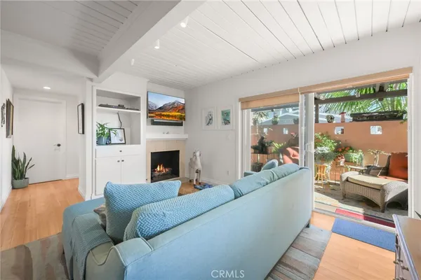 a living room with furniture a fireplace and a floor to ceiling window