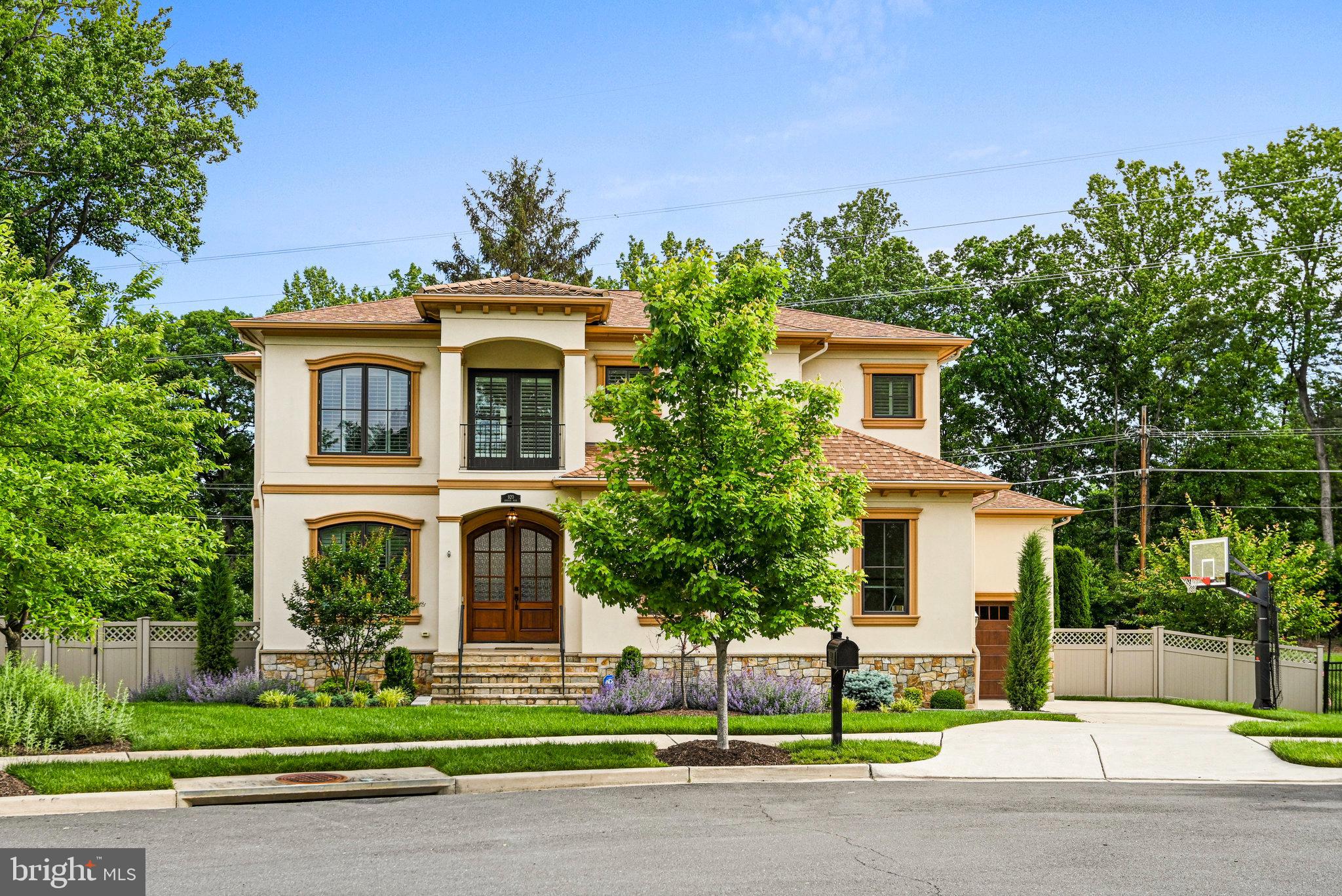a front view of a house with a garden and trees
